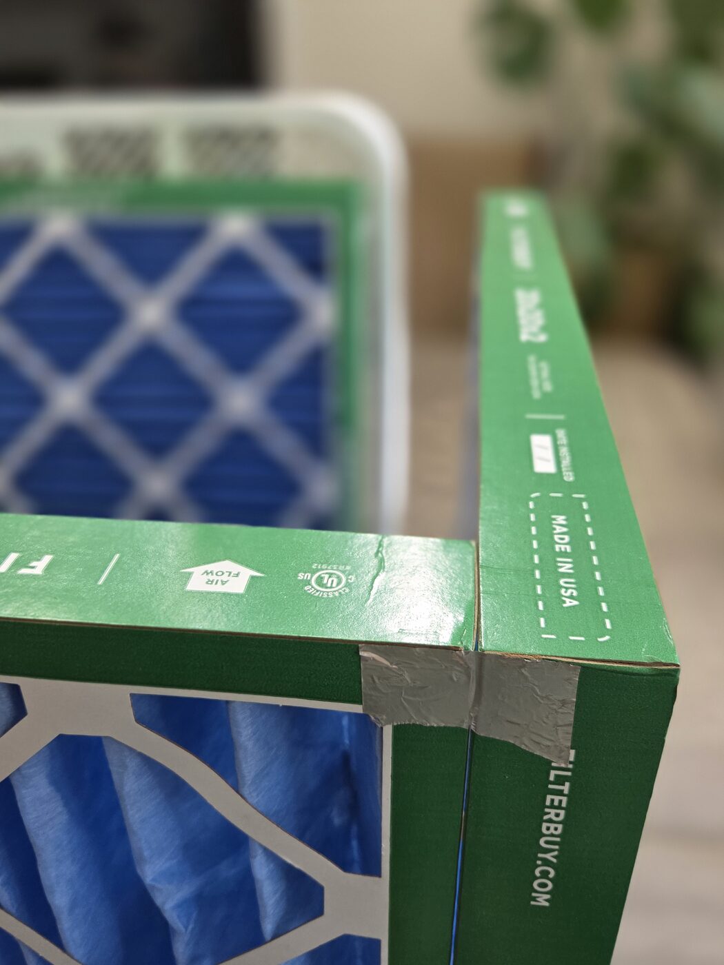Two furnace filters stood on edge and joined at a corner with a strip of foil tape.